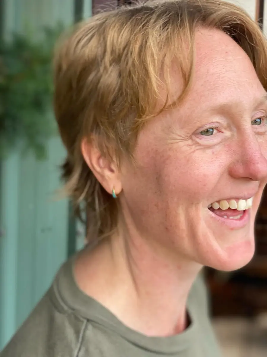 Smiling client in profile with a short strawberry blonde pixie