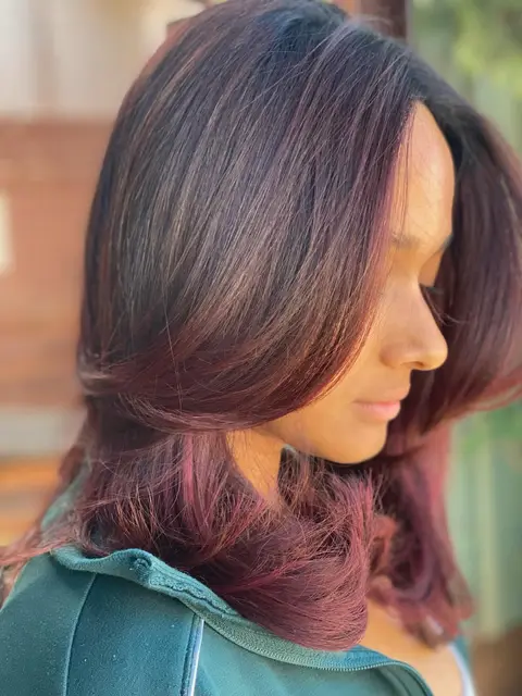 Side view of a burgundy berry layered cut with flicked-out ends