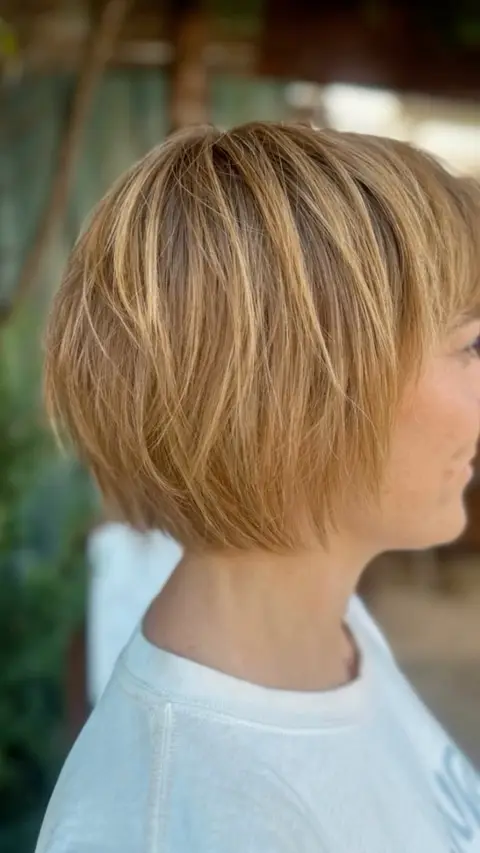 Side profile of a sleek golden copper textured bob with fine blonde highlights
